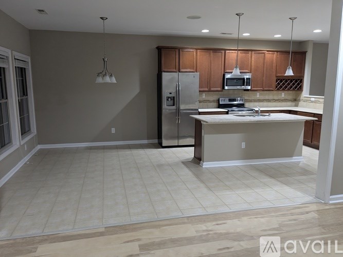 A kitchen with a refrigerator, microwave, and oven.