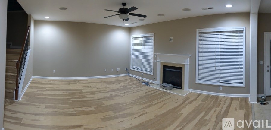 A living room with a fireplace and a staircase.