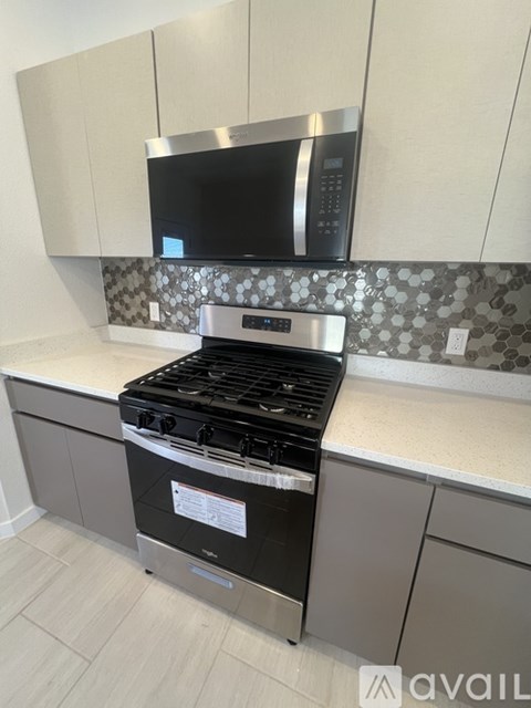 A modern kitchen with a stove top oven and microwave above it.
