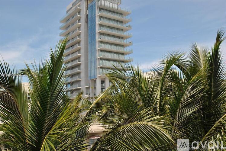 Palm trees in front of a tall building.
