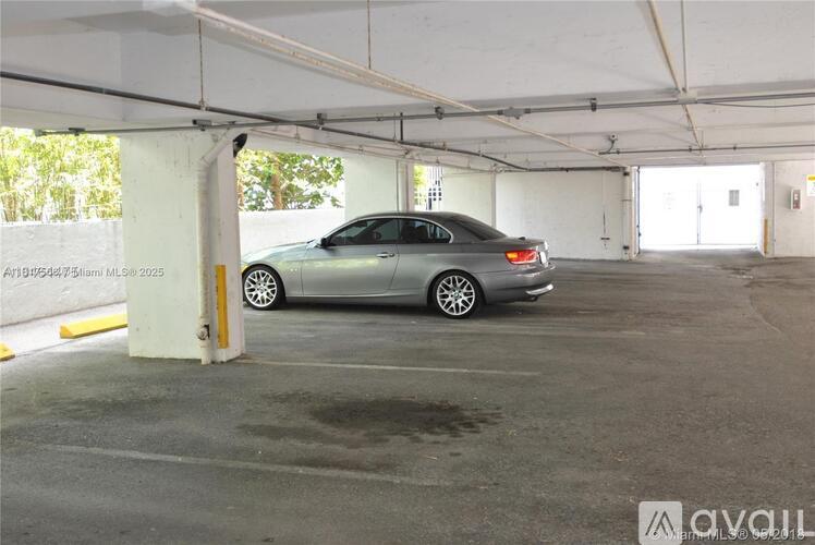 A grey car is parked in a spacious garage.