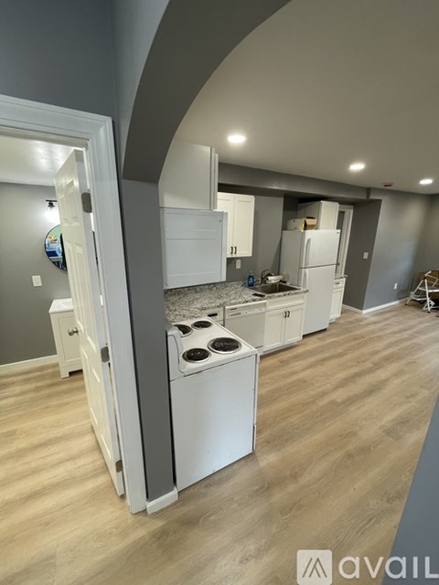 A kitchen with a white oven and wooden flooring.