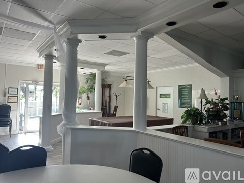 A white reception area with a counter and chairs.