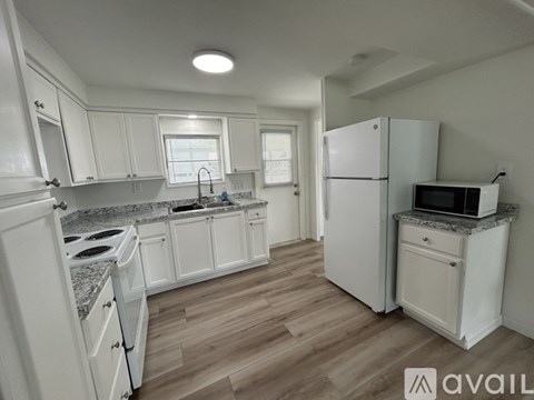 A kitchen with white cabinets and a granite countertop.