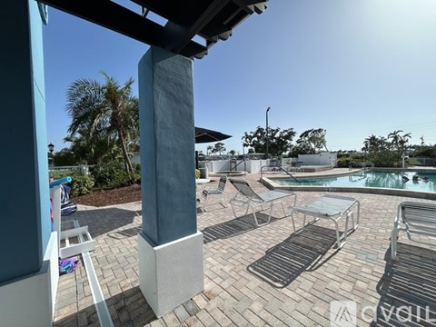 A pool area with a hot tub and lounge chairs.