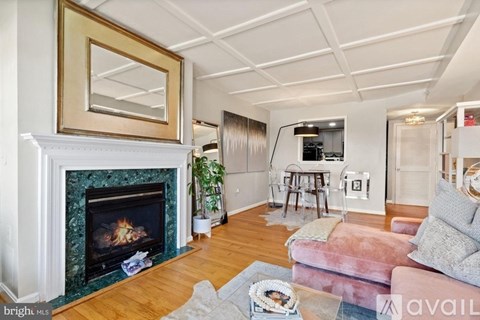 A living room with a fireplace and a painting above it.