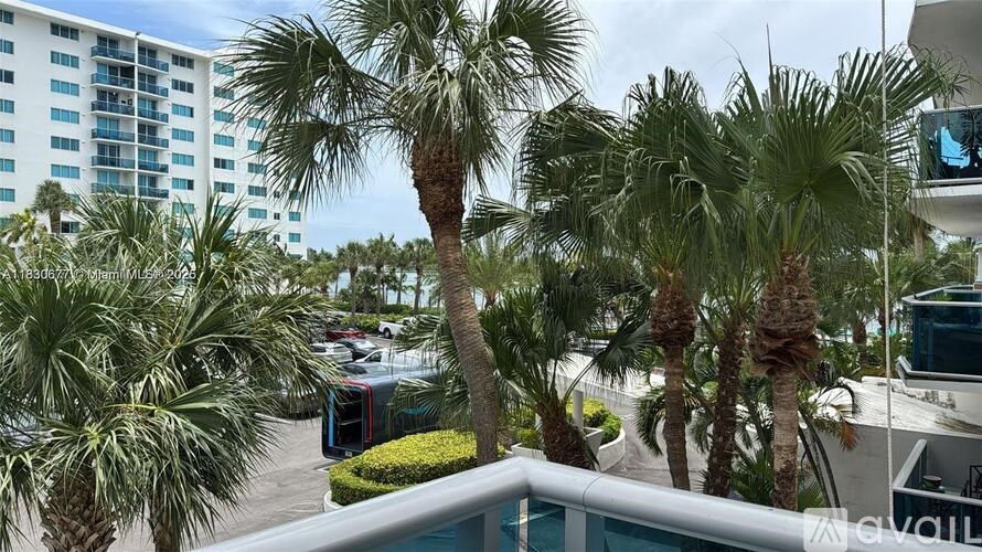 A balcony view of a building with palm trees.