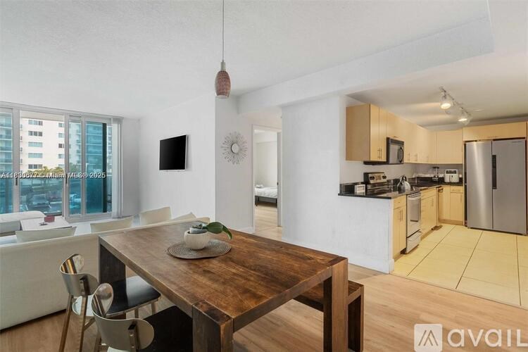 A modern kitchen with a wooden table and chairs in the foreground.