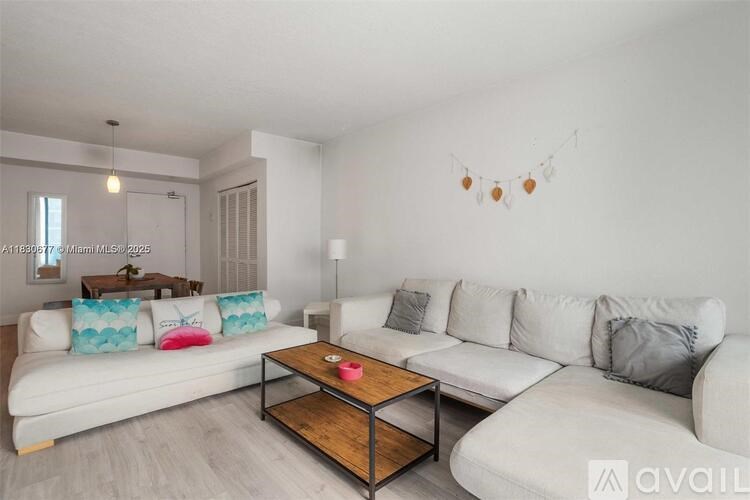 A living room with a white couch and a wooden coffee table.