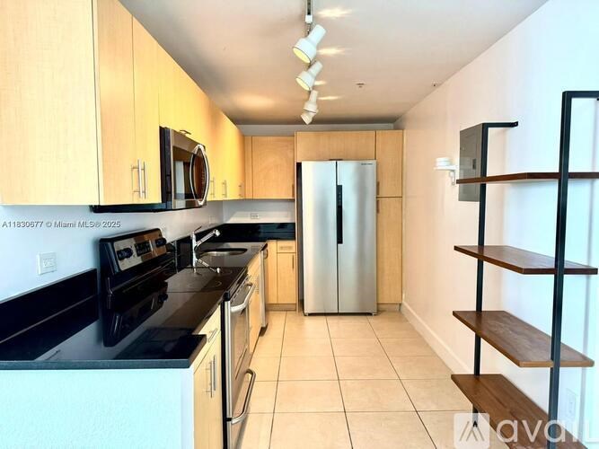 A kitchen with wooden cabinets and black appliances.