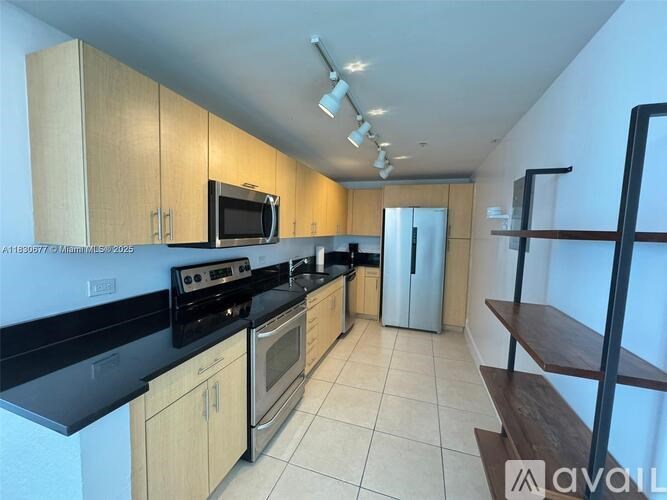 A kitchen with wooden cabinets and black countertops.