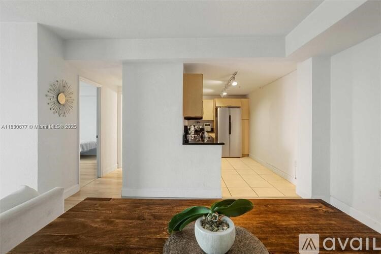 A room with a wooden floor and a plant in a pot.
