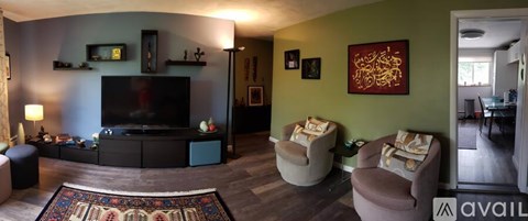 A living room with a large television and comfortable seating.