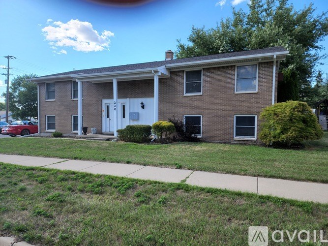 A brick house with a white door and windows.