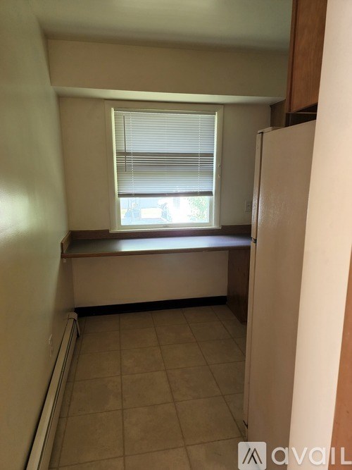 A small room with a window and a bench.