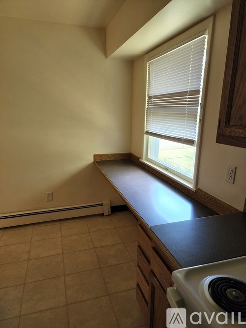 A room with a window and a wall-mounted heater.