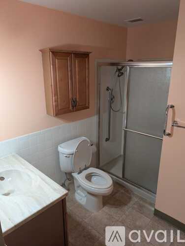A bathroom with a toilet, sink, and shower.
