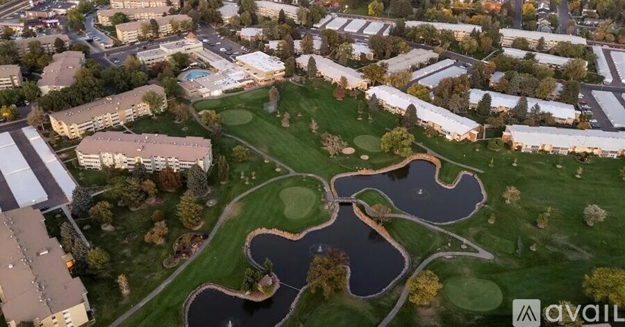 An aerial view of a park with a pond and a playground.