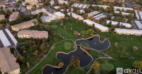 An aerial view of a park with a pond and a playground.