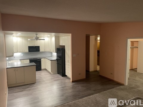 A kitchen with black appliances and wooden floors.