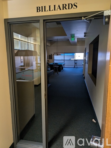 A room with a pool table and a door that says Billiards.