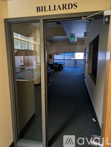 A room with a pool table and a door that says Billiards.
