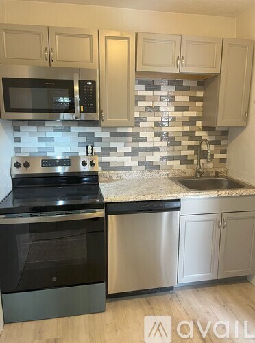 A kitchen with a black oven and a black microwave above a black dishwasher.