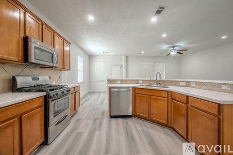 A kitchen with wooden cabinets and a stainless steel dishwasher.
