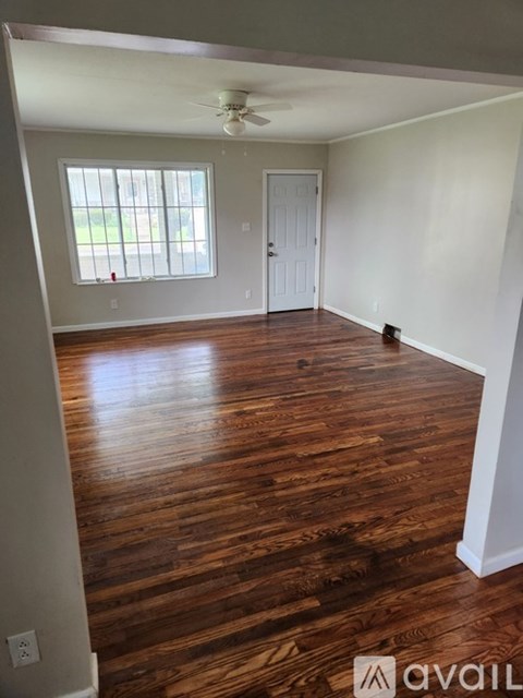 A room with wooden floors and a ceiling fan.