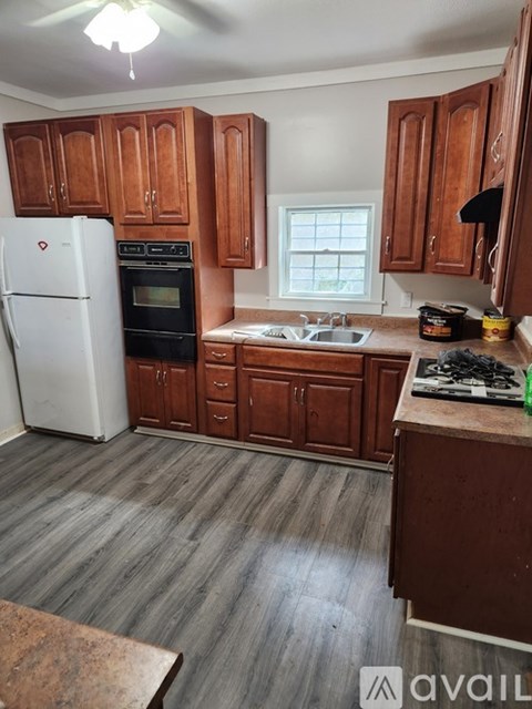 A kitchen with wooden cabinets and a white refrigerator.
