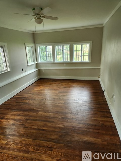 A room with wooden floors and a ceiling fan.