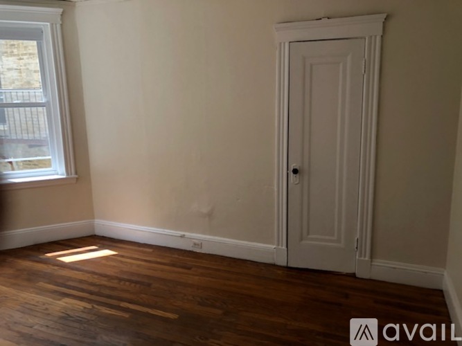 A room with a wooden floor and a white door.
