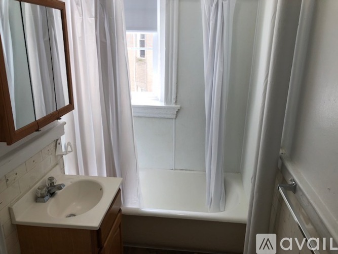 A bathroom with a sink, mirror, and bathtub.