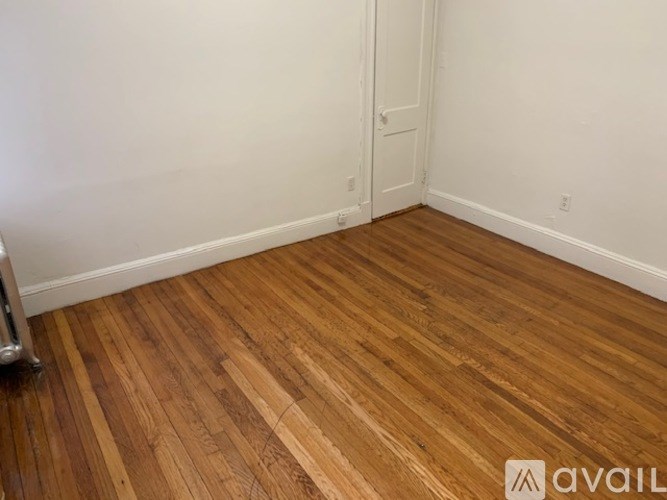 A room with wooden flooring and a white door.
