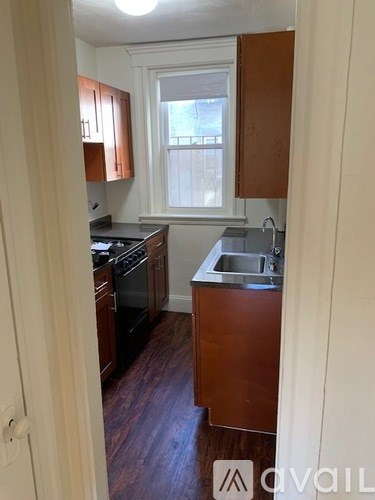 A kitchen with wooden cabinets and a window.