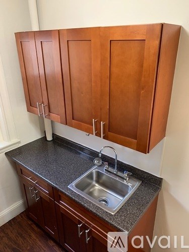 Brown wooden cabinets above a granite countertop with a sink.