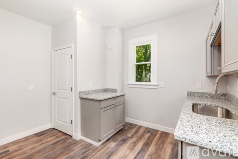 A kitchen with a granite countertop and wooden flooring.