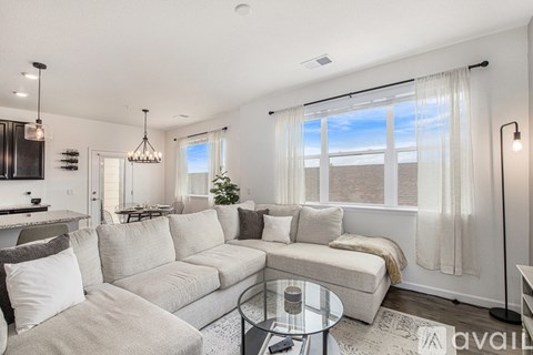 A living room with a large couch and a glass table.
