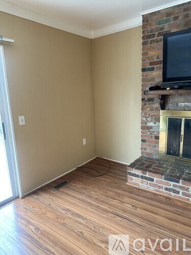 A living room with a fireplace and a flat screen TV mounted above it.
