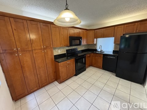 A kitchen with wooden cabinets and black appliances.