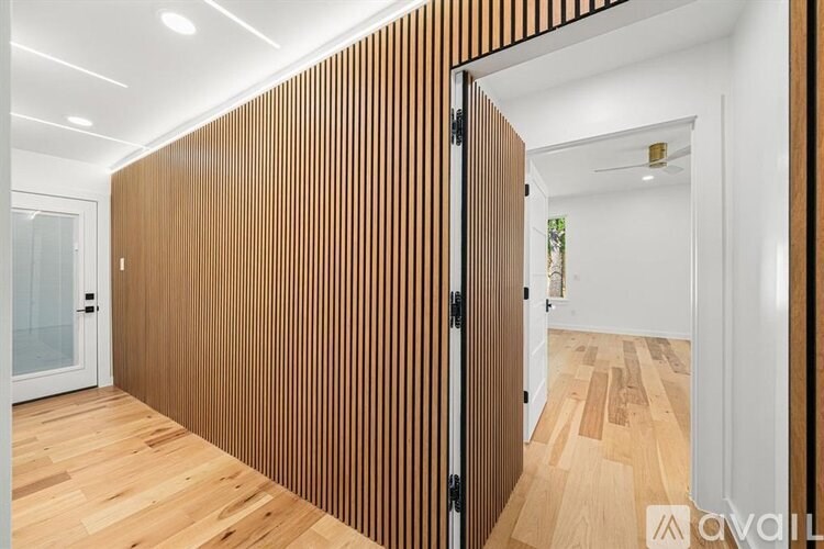 A room with a wooden floor and a wooden wall panel.