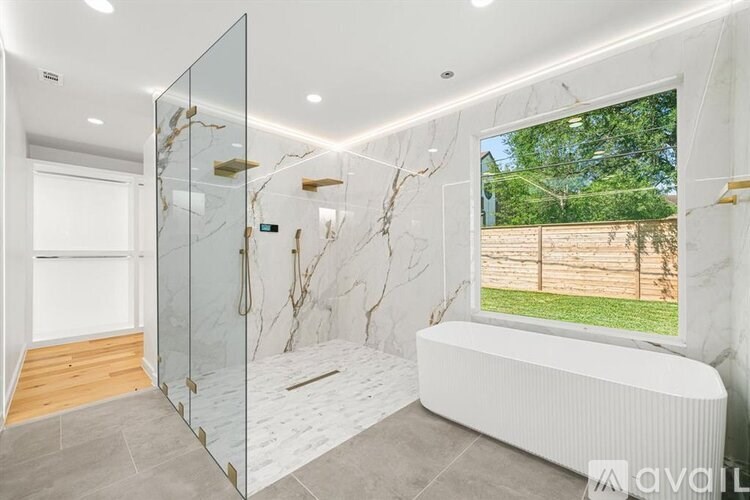 A bathroom with a walk-in shower and a large window.