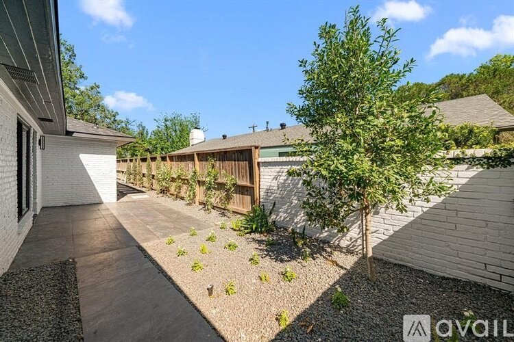 A modern house with a gravel garden area in front.
