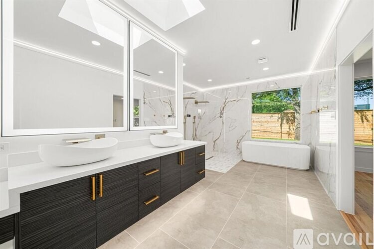 A modern bathroom with a large mirror and a white countertop.