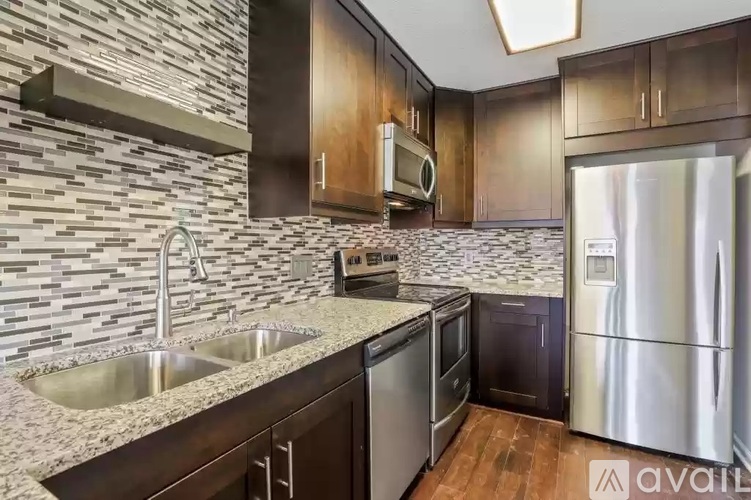 A kitchen with a stone backsplash and stainless steel appliances.