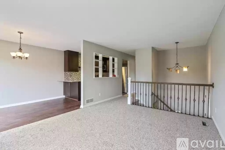 A spacious living room with a staircase leading to the upper floor.