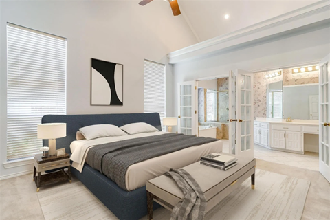 A bedroom with a large bed and a ceiling fan.