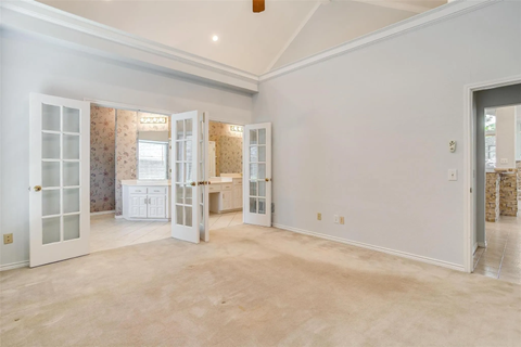 A spacious room with a kitchen area and a dining table.