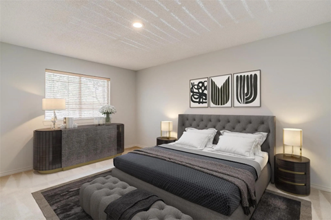 A bedroom with a large bed and a grey headboard.
