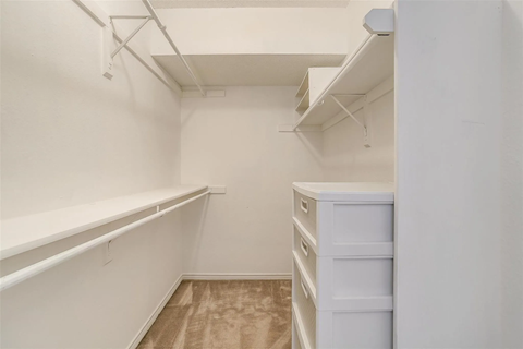 A white refrigerator in a small, empty kitchen.